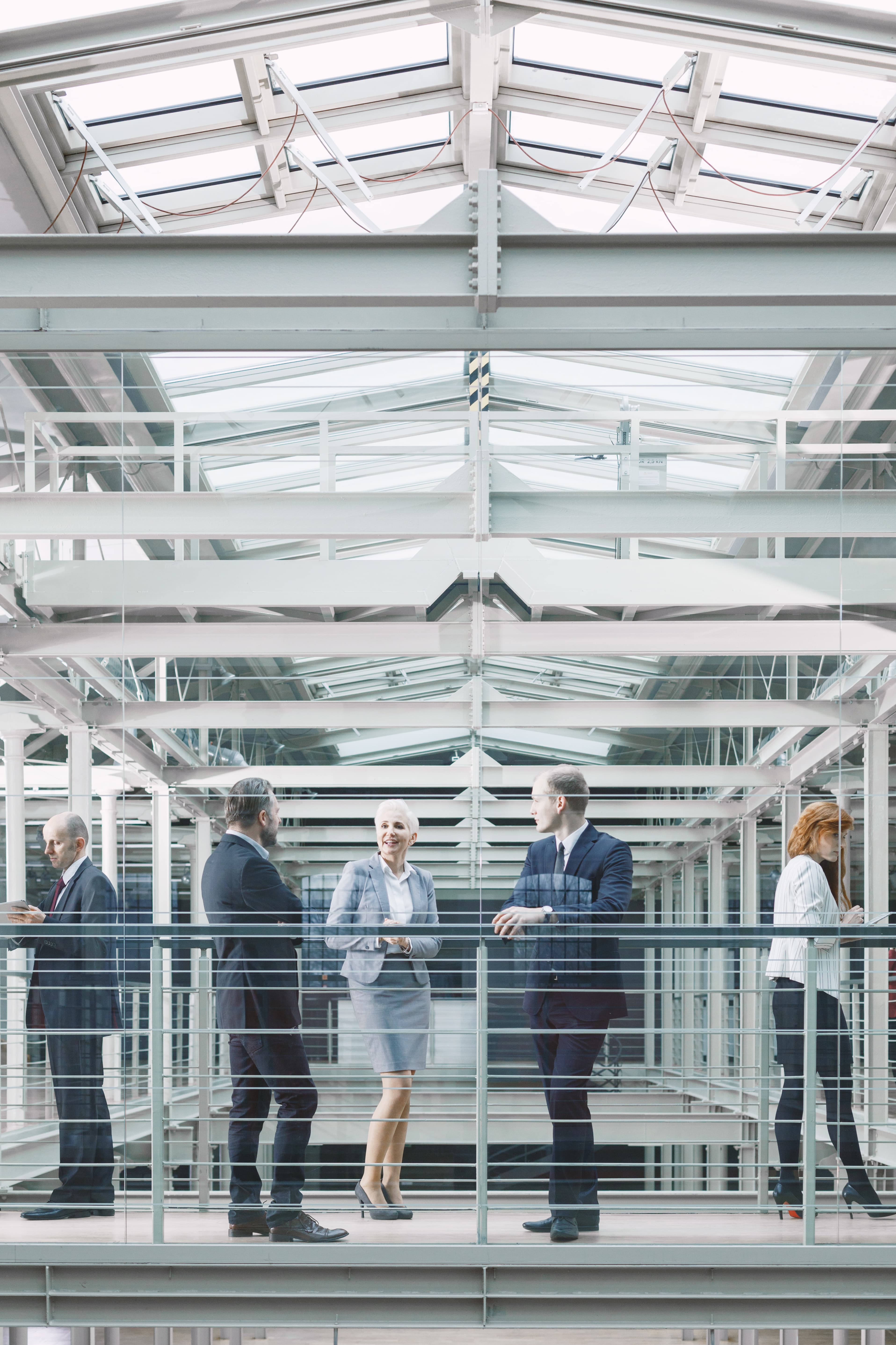 Executives in conversation inside an institutional office atrium